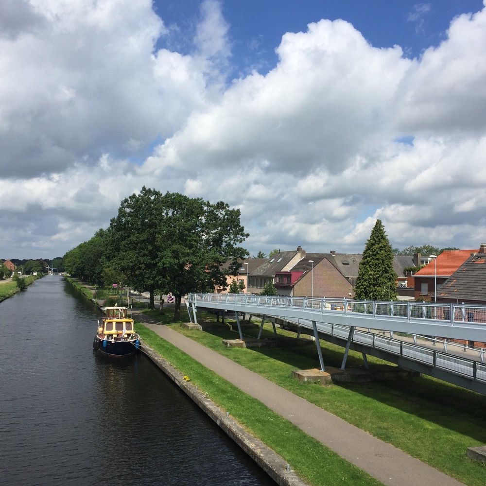 gele en blauwe boot in kanaal vanaf fietsbrug
